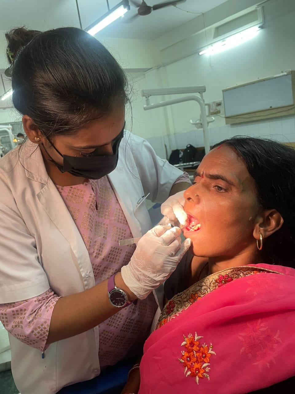 Dentist providing dental treatment to an adult female patient